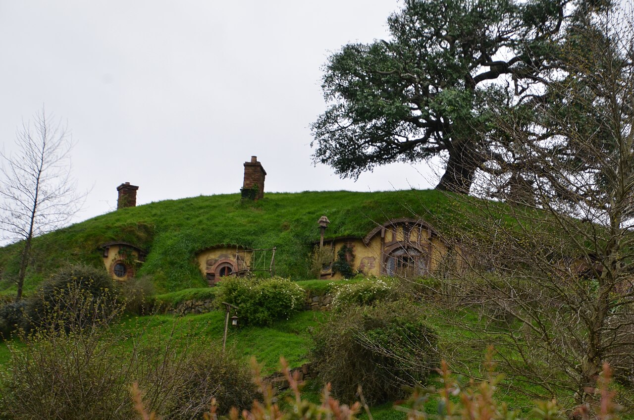 Cul-de-Sac à Hobbiton : portes rondes dans une colline, un chêne au sommet.